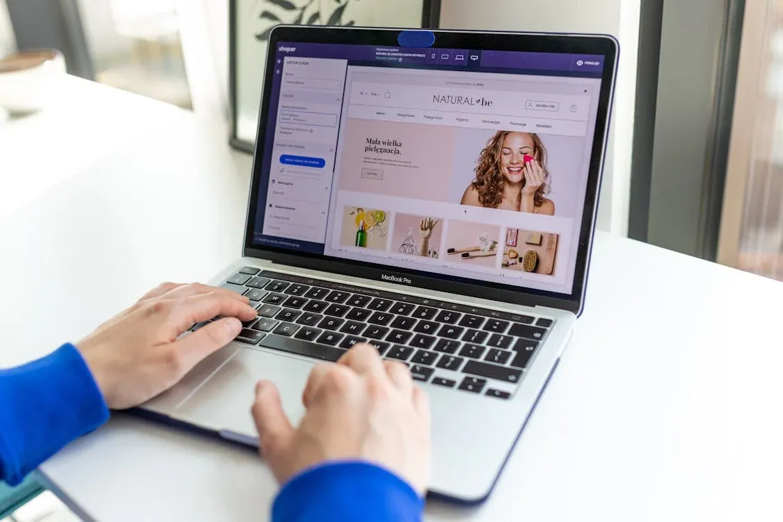 Hands typing on a laptop with an e-commerce website open, showcasing online shopping