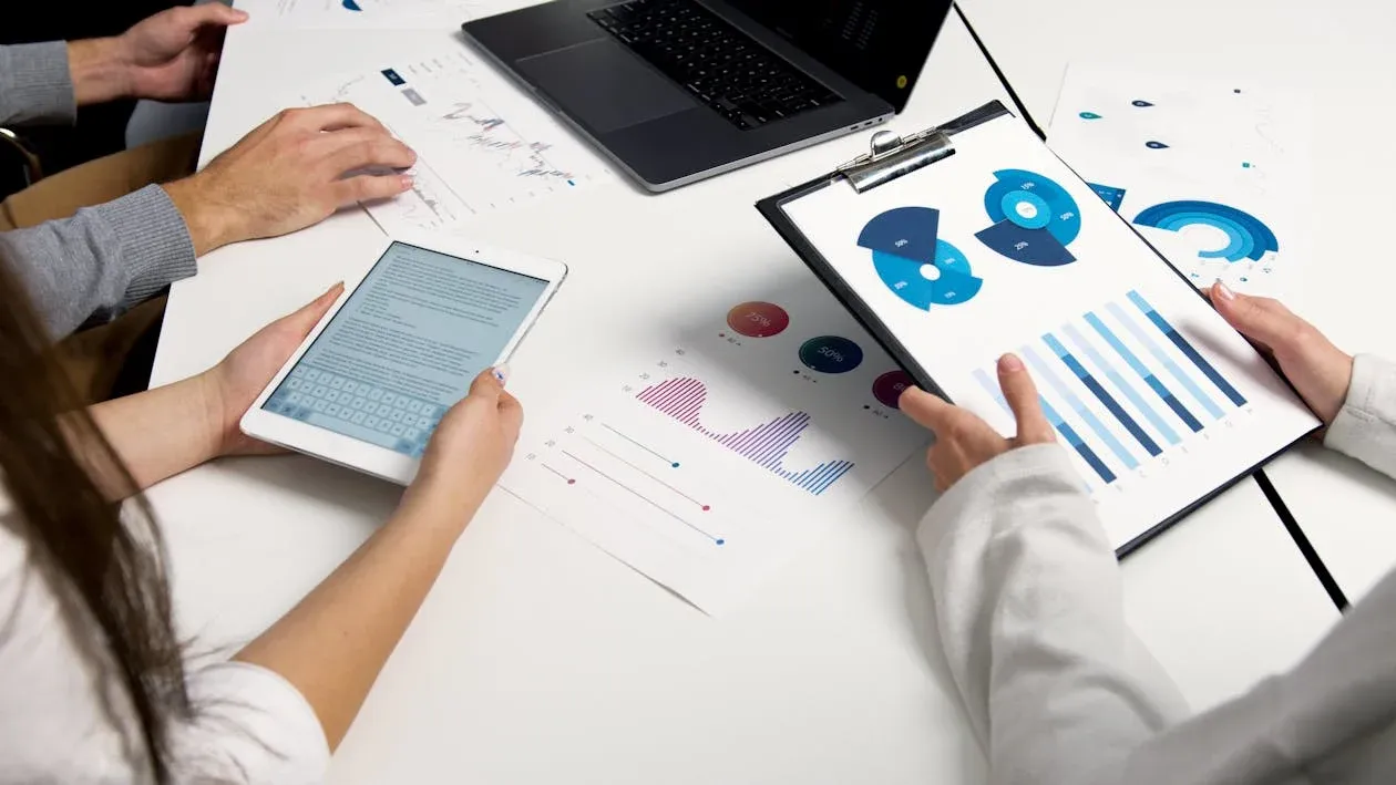 Team analyzing financial charts and digital reports during a business meeting