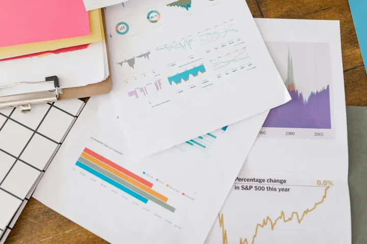 Close-up of business analytics charts and graphs on papers and clipboard
